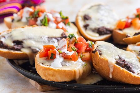 Molletes. Vegetarian Mexican food similar to bruschetta. Refried beans and melted cheese on toasted bread.の写真素材