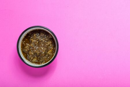 Cooked salsa verde on enamel bowl isolated on pink background. Mexican food, condiments.の写真素材
