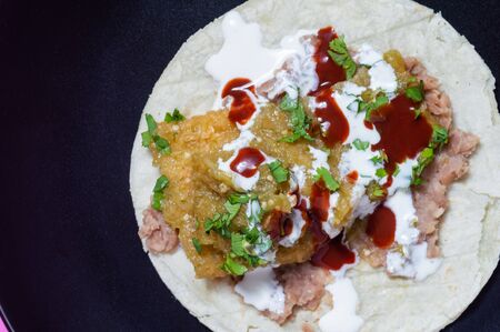 Pork rinds in green salsa, chicharrones in salsa verde, Mexican food. A traditional and popular breakfast in Mexico, served with refried beans and soft corn tortillasの写真素材