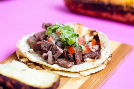Mexican carne asada tacos, literally grilled meat tacos. These are chopped barbecued beef served on...