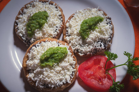 Acapulco Style Mexican Picaditas. Corn Sopes With Black Beans, Cheese and Green Salsa.