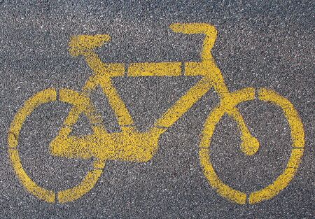 Yellow cycle signal on asphalted bicycle lane
