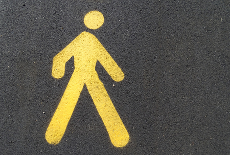 Yellow pedestrian sign painted on a asphalt groundの写真素材