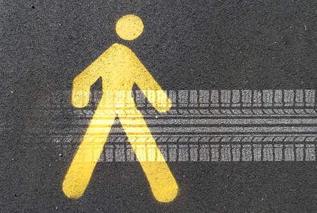 Painted sign on asphalt for pedestrian lane and tire track. Concept: road hazards for pedestrians                              の写真素材