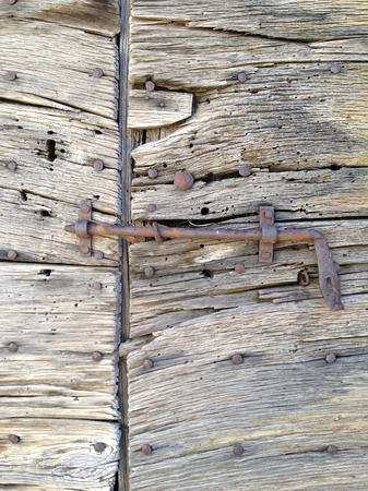 Rusty latch fixed on an old wooden doorの写真素材