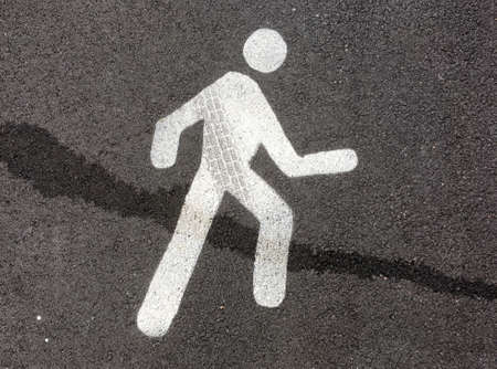 Pedestrian street sign on asphalt floor with tire track and liquid stainの写真素材