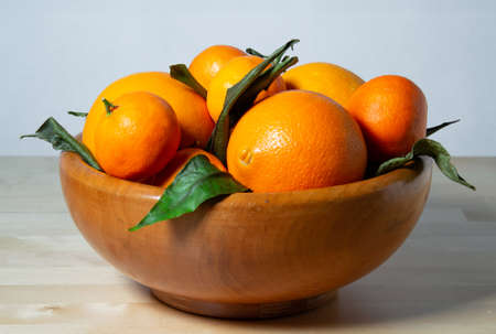 Some oranges in a basket over a wooden surfaceの写真素材