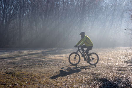 Lonate Pozzolo, Varese - Italy - December 13.2020 Cyclist ride trails in the woods in winter.のeditorial素材
