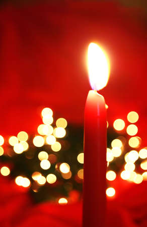 Red candle, with colorful lights behind.の写真素材