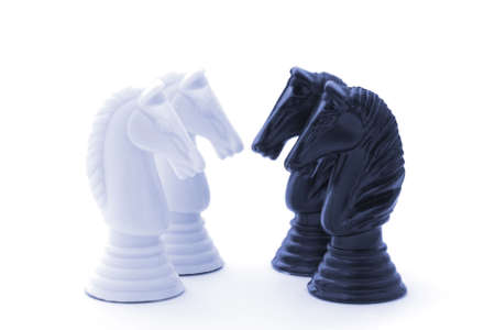 Face off between two white knights and two black knights.  Soft-focus, blue toned.の写真素材