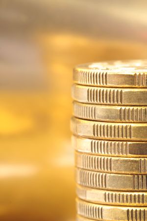 Gold coins in a stack, with golden background.