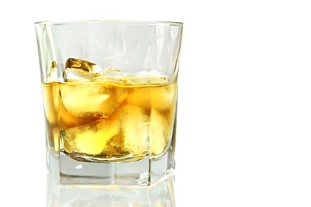 Whiskey on ice, reflected on white surface.  Scotch on the rocks - lovely golden smokey drink.の写真素材