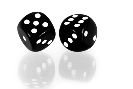Black and white dice reflected on a white surface.の写真素材