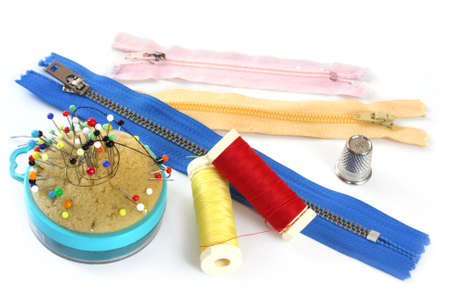 Collection of sewing items, isolated on white.  Includes pin cushion, pins, needles, thimble and...