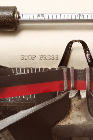 "STOP PRESS" typed on aged paper in vintage typewriter.  Close-up view, showing decades of dust.の写真素材