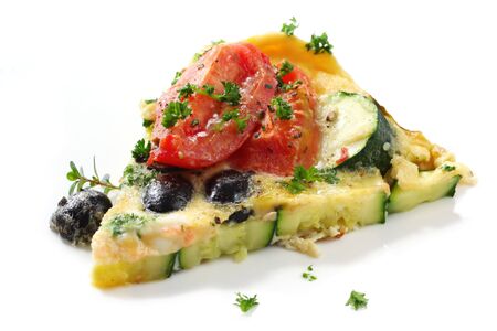 Wedge of vegetable frittata.  Italian style omelette, with roma tomatoes, zucchini (courgette) and black olives.  Garnished with parsley and thyme.の写真素材