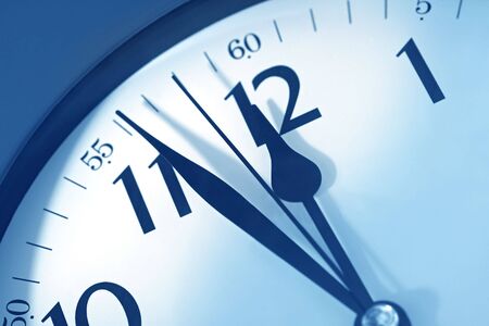 Clockface showing just before midnight.  Blue toned image, with soft focus.