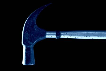 Rusted old hammer against black background, in blue tone.の写真素材