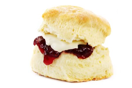 Fresh-baked scone, with strawberry jam and whipped cream.  Isolated on white.  Yummo!の写真素材