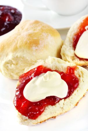 Fresh scones with strawberry jam and fresh cream, served with a cup of tea.  Known as a Devonshire tea or cream tea.の写真素材