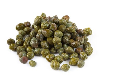 Capers, in close-up, casting soft shadow on white surface.の写真素材