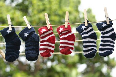 Baby socks on the clothesline.  Cheerful navy blue and red socks.の写真素材