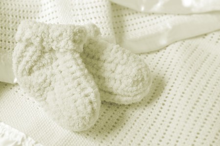 Baby booties on a soft baby blanket.  Soft and warm for the new arrival.の写真素材