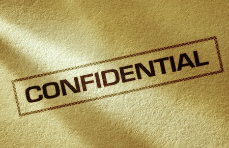 "Confidential" printed on textured paper, in macro.  Angled warm lighting.の写真素材