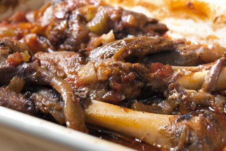 Slow-cooked lamb shanks with vegetables, in a casserole dish, ready for serving.  の写真素材