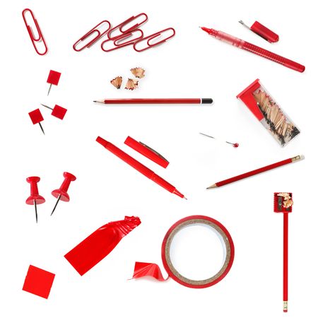 Collection of red stationery, including paperclips, pushpins, pencils, pens, pins, sharpener, and tape.  Isolated on white.の写真素材