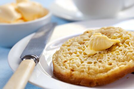 Hot buttered English crumpets.  Focus on melting butter.の写真素材