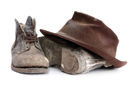 Battered old workboots and felt hat, isolated on white.  Well used from the 1940's until recently.の写真素材