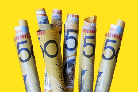 Australian fifty dollar notes "growing" over bright yellow background.の写真素材