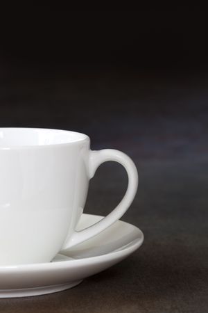 White coffee cup and saucer, over slate background.の写真素材