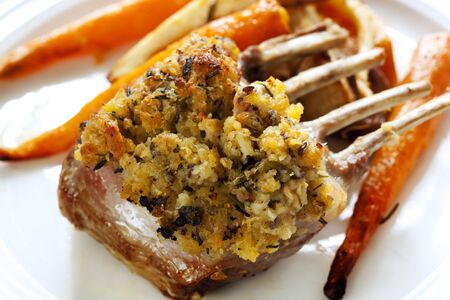 Rack of lamb with a herb crust, served with roasted vegetables.の写真素材