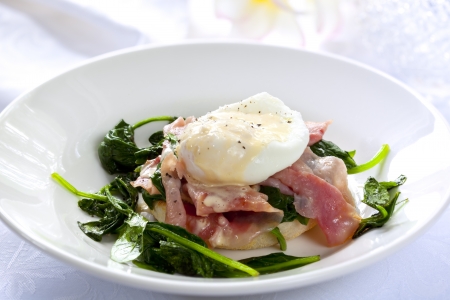 Eggs Benedict.  Toasted muffin topped with wilted spinach, ham, poached egg, and rich hollandaise sauce.  Delicious!の写真素材