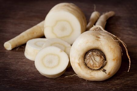 Parsnips on a chopping board, whole and sliced.の写真素材