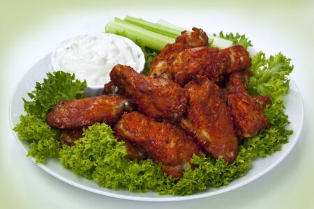 Platter of buffalo wings with a blue cheese dipping sauce and celery sticks.  Hot and spicy!の写真素材