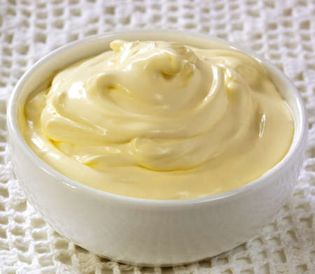 Fresh cream in a small white bowl, over lace background.の写真素材