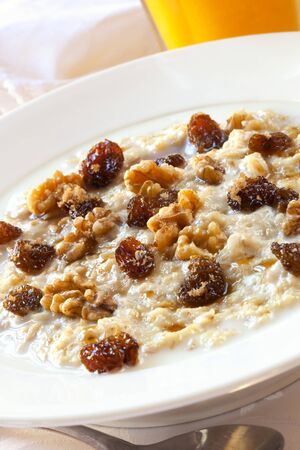 Oatmeal topped with raisins, walnuts and brown sugar.  Delicious healthy porridge.の写真素材
