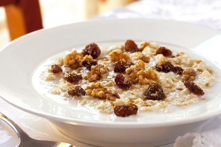 Bowl of oatmeal topped with raisins, walnuts and brown sugar.  Healthy eating.の写真素材