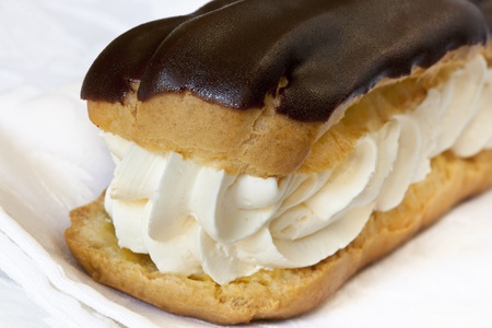 Chocolate eclair filled with fresh cream.  Close-up view.