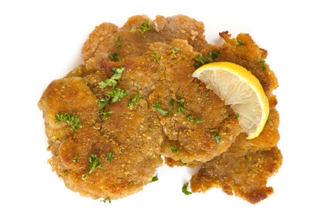 Schnitzel, garnished with lemon and parsley, isolated on white.の写真素材