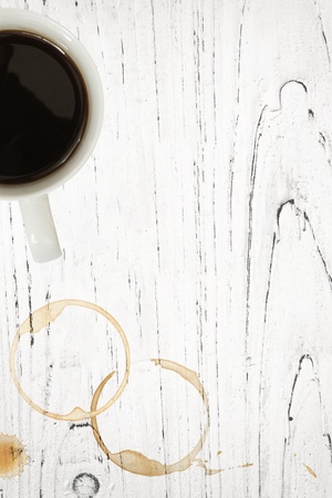 Coffee mug with stains and splashes overgrunge white timber background.の写真素材
