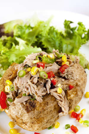 Baked potato with tuna, sweet corn, capsicum and shallots, served with salad.の写真素材