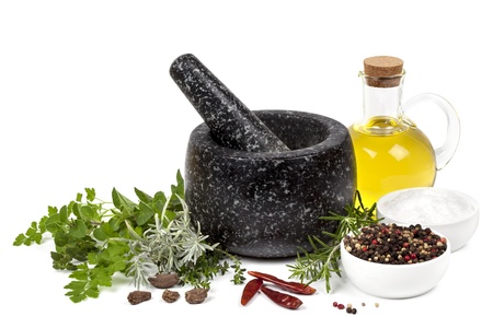Black marble mortar and pestle, with herbs, spices and olive oil, isolated on white の写真素材
