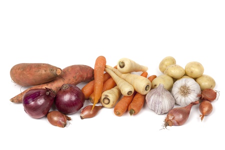 Variety of root vegetables isolated on white   Includes carrots, parsnips, red onions, shallots, garlic, potatoes, and sweet potatoes の写真素材