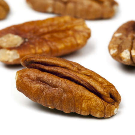 Pecan nuts in closeup, over white background.  Square crop.