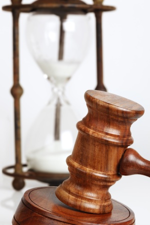 Gavel and block, with antique hourglass behind の写真素材