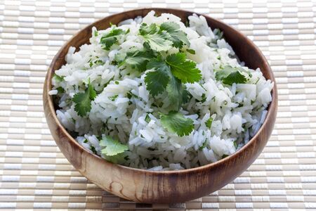 White rice with coriander or cilantro, in wooden bowl の写真素材